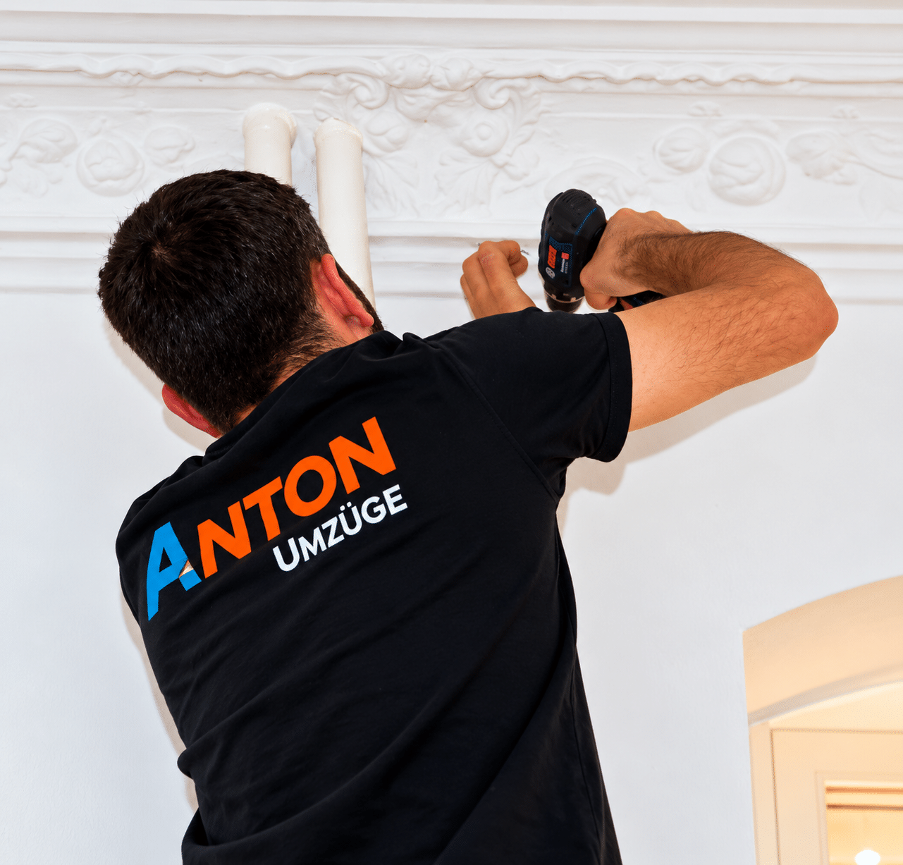 Home worker drilling ornate plaster molding